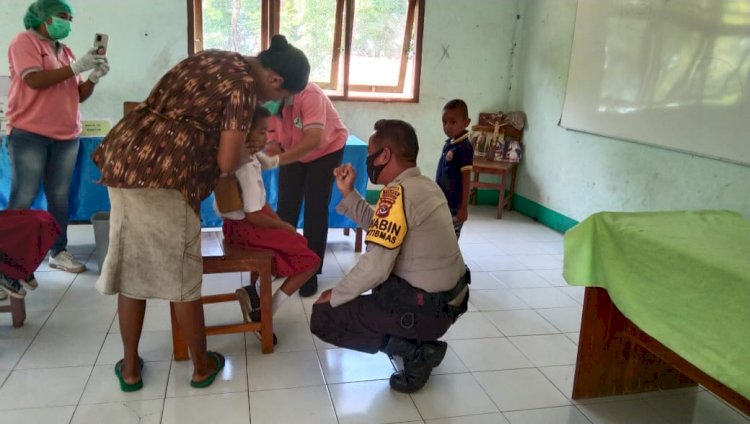 Cegah Penyebaran Covid-19 di Daerah Kab. Lembata, Bhabinkamtibmas Desa Penikenek dampingi Vaksinasi Anak 6 - 11 Tahun